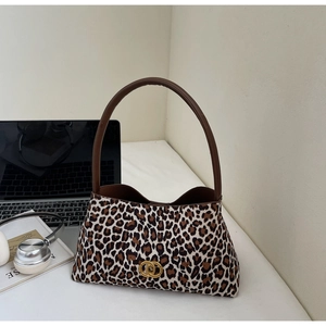 Close-up of leopard print shoulder bag with gold metal logo and brown leather strap