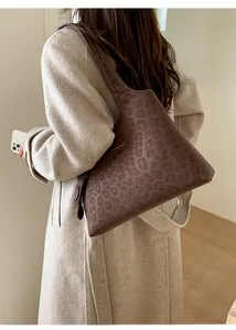 Détail d'un sac cabas léopard porté avec un manteau beige pour un look d'automne chic