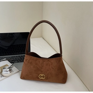Detail of a dark brown suede underarm bag featuring a golden double-ring metal buckle