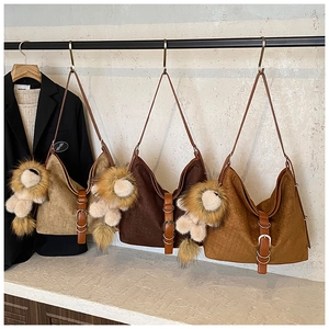 Detail view of large vintage tote bags in brown and khaki with woven texture and lion charm