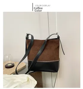 Detail of brown suede and black faux leather tote bag with metal zipper and strap