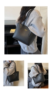 Close-up of black pebble leather texture with gold stamped logo on the tote bag
