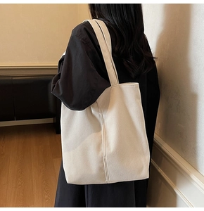Close-up of beige corduroy tote bag showing ribbed texture and large capacity design