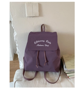 Gros plan détaillé d'un sac à dos violet à cordon avec impression graphique blanche sur tissu