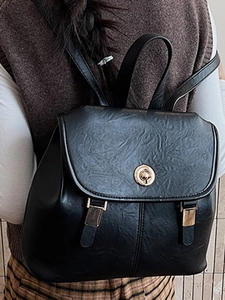 Retro black faux leather backpack with gold buckle and adjustable straps shown on model