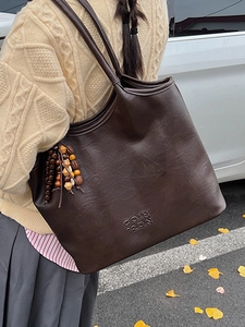 Sac cabas vintage en cuir marron foncé avec logo embossé et pompon en perles de bois