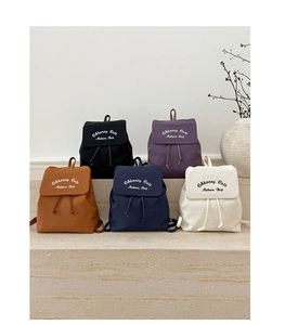 Vue détaillée de cinq sacs à dos minimalistes en plusieurs coloris sur des marches en pierre