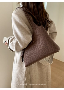 Détail du sac cabas léopard avec texture en cuir et étiquette au design minimaliste
