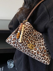 Vintage leopard print shoulder bag with gold logo and wooden bead accessory shown on model