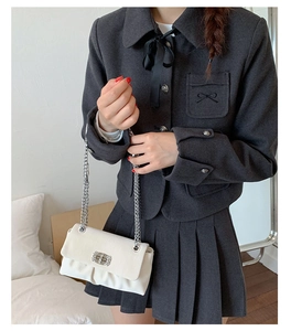 Detail of white pleated leather bag with silver metal twist lock and chain strap