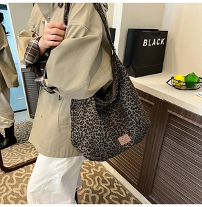 Detail of a leopard print canvas tote bag styled with a khaki coat for a retro look