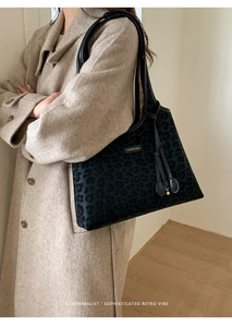 Gros plan sur un grand sac cabas léopard avec étiquette de mode et pendentif à cordon chic