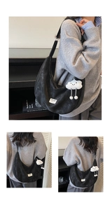 Detail view of black suede moon bag with a white brand label and cute cloud plush charm