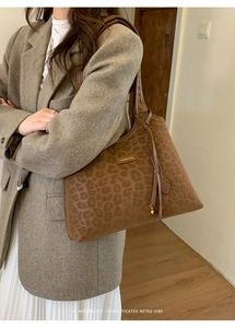 Sac fourre-tout à motif léopard marron porté par un mannequin en veste grise
