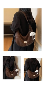 Detail view of dark brown suede crescent bag with adjustable strap and cloud charm