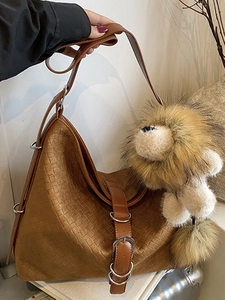 Brown woven texture tote bag with lion plush pendant and adjustable shoulder strap