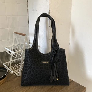 Détail du sac cabas léopard noir avec texture en daim et breloque à franges chic