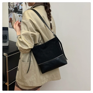 Detail showing the mixed suede and leather textures of the large black tote shoulder bag