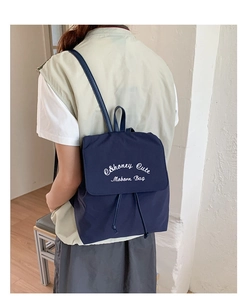 Détail du logo brodé et du tissu en nylon sur ce sac à dos bleu marine élégant