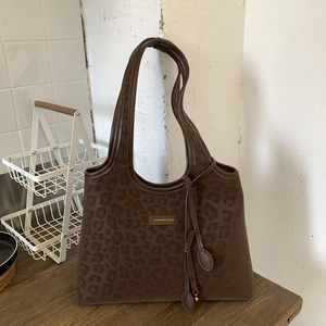 Détail du cabas à motif léopard avec logo doré et texture en daim de haute qualité
