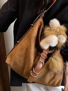 Vintage brown woven tote bag with adjustable straps and yellow fur ball accessory