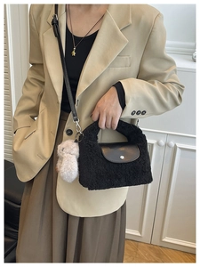 Detail of black faux fur handbag with leather flap and cute white rabbit keychain charm