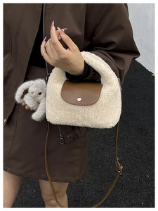 Detailed macro view of plush beige faux fur texture with brown leather flap and silver buckle