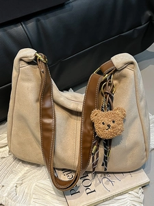 Minimalist beige suede hobo bag with wide brown shoulder strap and cute bear charm