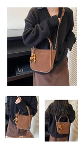 Detail view of large brown faux suede bucket bag with boho beads and detachable strap