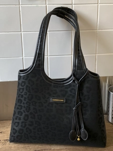 Sac fourre-tout noir minimaliste avec motif léopard et détails de glands élégants