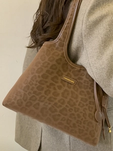 Grand sac cabas à imprimé léopard avec gland porté sur un manteau en laine élégant