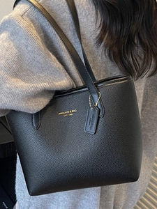 Large black pebbled leather tote bag with gold brand lettering and slim shoulder straps