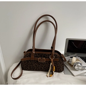 Detail of leopard print shoulder bag with brown leather handles and bead tassel