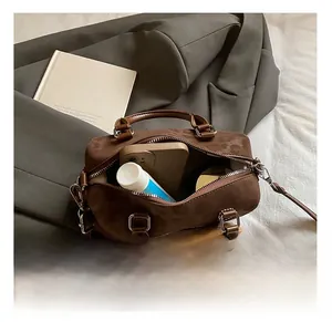 Detail view of the spacious interior of this brown suede Boston bag with phone and essentials