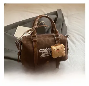 Detail of dark brown Boston bag with star embroidery and cute biscuit plush pendant