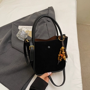 Large black faux suede bucket bag with wooden bead tassel and adjustable shoulder strap