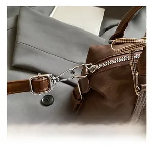 Close-up of premium silver metal hook and adjustable leather strap on a Boston bag