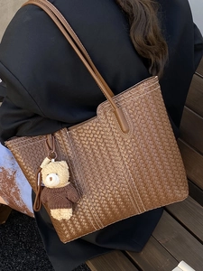 Vintage brown woven tote bag with large capacity and a cute plush bear pendant for daily commute