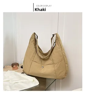 Detail of khaki Hobo tote bag with quilted nylon texture and silver snap button pocket