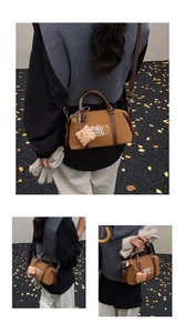 Detail of a brown Boston bag with embroidery, plush pendant, and plaid bow decoration