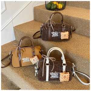 Boston bags in canvas and leopard print with biscuit charms on beige carpeted stairs