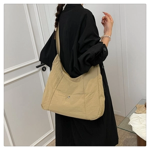 Khaki nylon tote bag showing side view and large capacity on a model silhouette