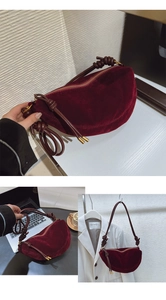 Detail view of dark red velvet crescent bag featuring leather knots and metal hardware accents