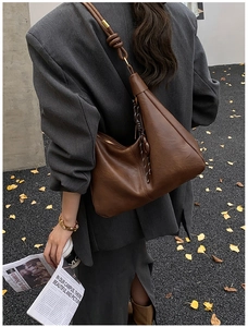Detail of soft dark brown leather tote with a stylish knotted wide shoulder strap