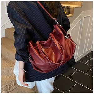 Detail of burgundy vintage tote bag showing premium PU leather texture and silver hardware
