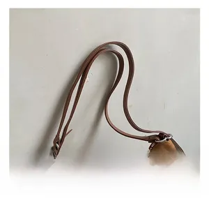 Detailed macro view of the brown suede handbag featuring metallic zipper and silver buckle