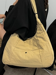 Beige nylon tote bag with pleated texture and adjustable strap for daily commute