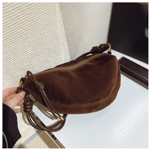 Detail of dark brown suede crescent bag with knotted strap and gold zipper hardware