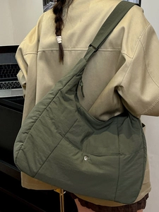 Minimalist olive green quilted nylon tote bag with adjustable strap and silver buckle
