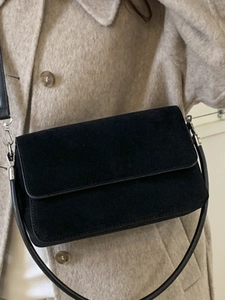 Minimalist black faux suede crossbody bag with elegant silver hardware and shoulder strap
